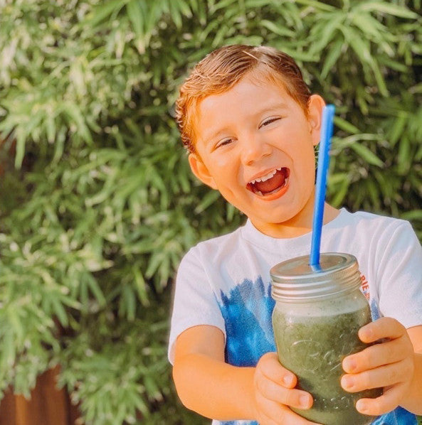 Very happy young boy enjoying a Super Green smoothie