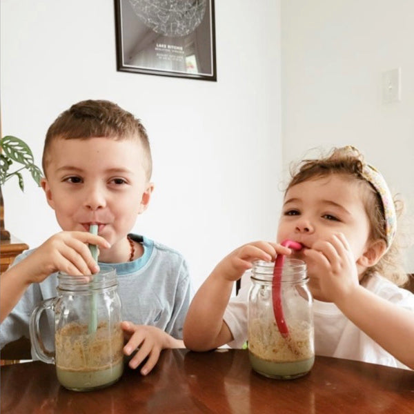 Two young kids enjoying their Super Greens smoothies